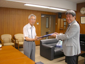 山口雅彦先生(大学院薬学研究科長・薬学部長)より感謝状を受け取る矢萩信夫N.M.I.所長